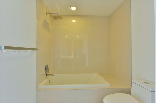 full bathroom with toilet and tiled shower / bath