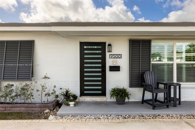 view of exterior entry featuring brick siding