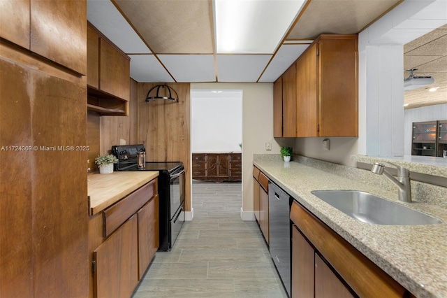 kitchen with light countertops, a paneled ceiling, black range with electric cooktop, a sink, and stainless steel dishwasher