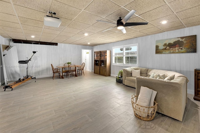 living room with a paneled ceiling, ceiling fan, and wood-type flooring