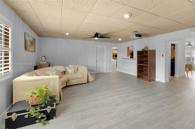 living room featuring ceiling fan and a paneled ceiling