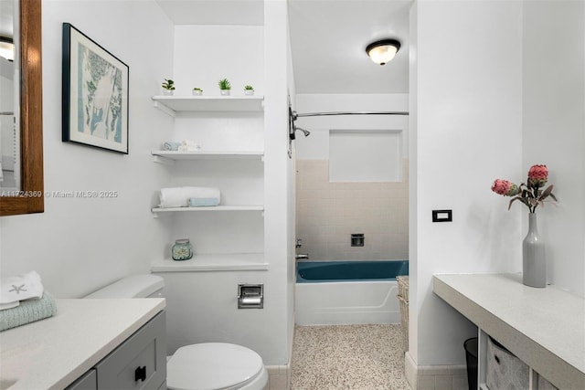 bathroom with bathtub / shower combination, speckled floor, toilet, and vanity