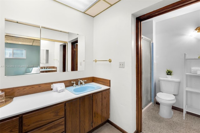 full bath featuring toilet, speckled floor, vanity, a shower stall, and baseboards