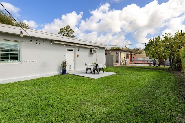 rear view of house featuring a yard, a patio, and a wall mounted air conditioner