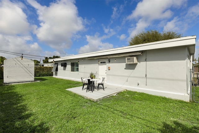 rear view of property with an outdoor structure, stucco siding, a lawn, a patio area, and a storage shed