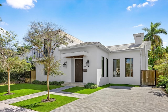 view of front of property with fence, a front lawn, and stucco siding