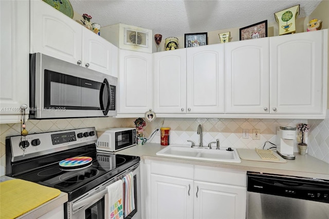 235 Kent N Unit 235, West Palm Beach, FL 33417 - kitchen featuring a sink, appliances with stainless steel finishes, white cabinetry, and visible vents