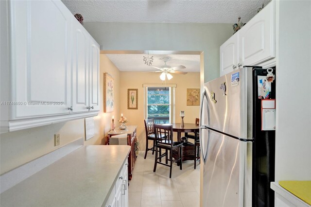 235 Kent N Unit 235, West Palm Beach, FL 33417 - kitchen featuring freestanding refrigerator, light tile patterned flooring, ceiling fan, light countertops, and white cabinets