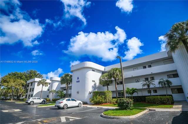 view of building exterior featuring uncovered parking and a residential view