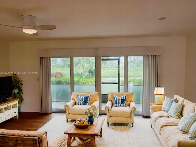 living room with ceiling fan, wood finished floors, and baseboards