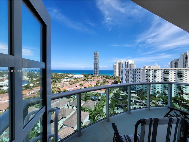 balcony featuring a water view and a city view