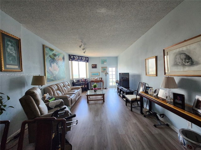 living area with a textured ceiling, baseboards, track lighting, and wood finished floors