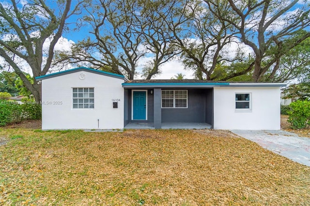 single story home featuring a front yard and stucco siding