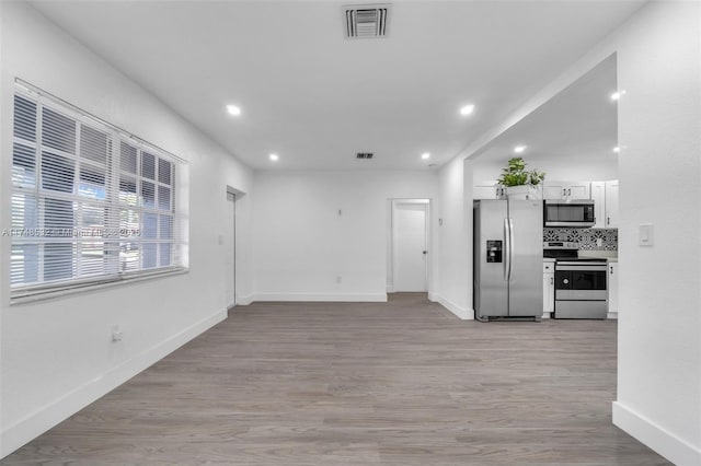 kitchen with light wood finished floors, visible vents, white cabinetry, and stainless steel appliances