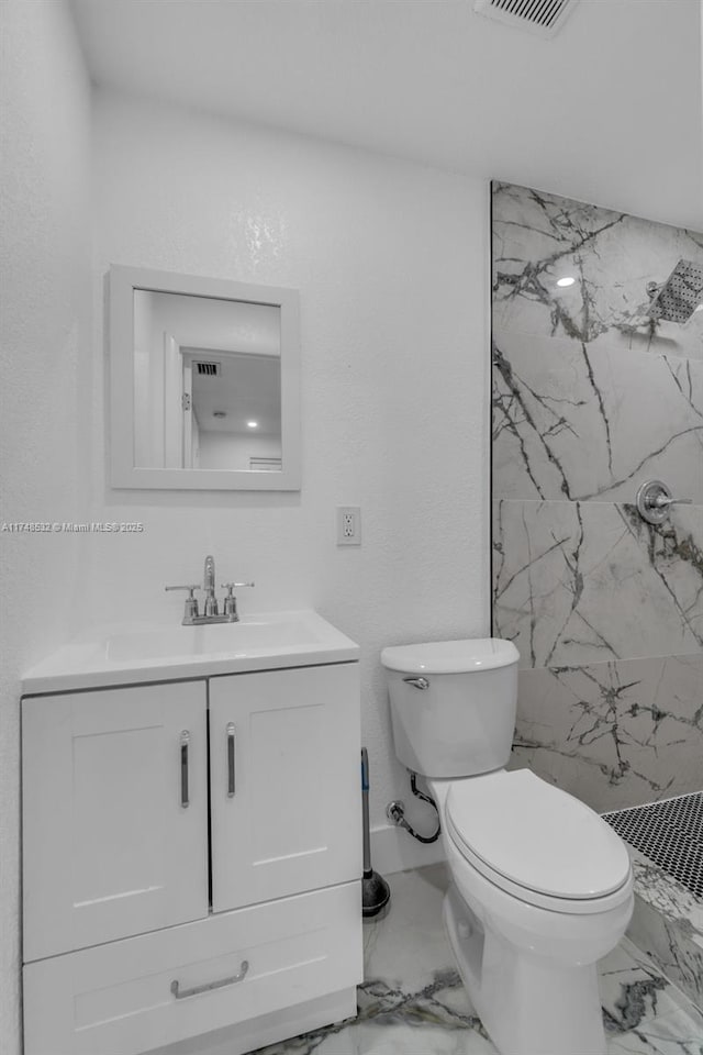 bathroom featuring a marble finish shower, visible vents, toilet, marble finish floor, and vanity