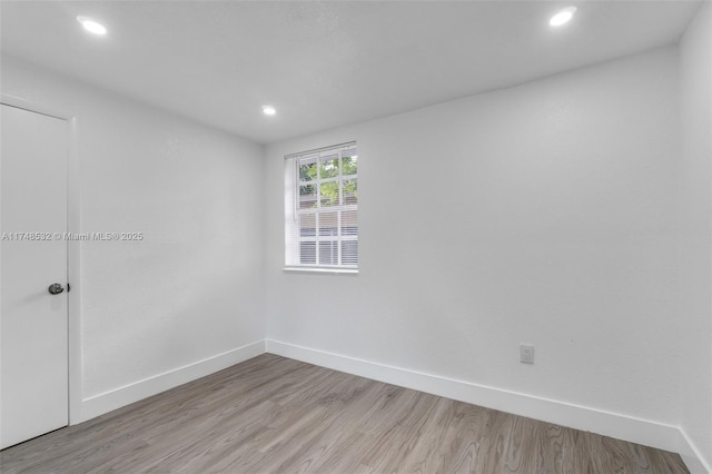 spare room with recessed lighting, wood finished floors, and baseboards