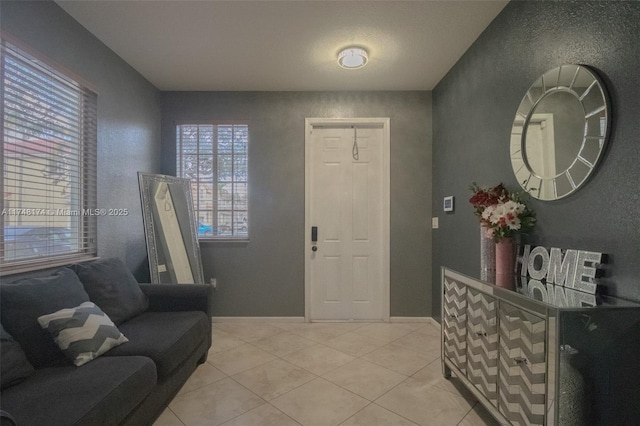 entryway with light tile patterned floors and baseboards