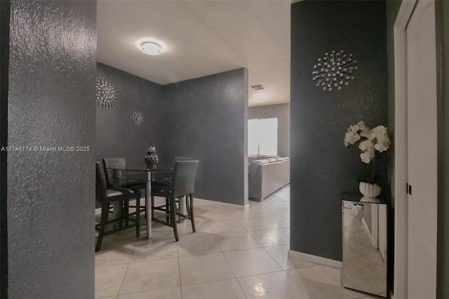 dining area featuring light tile patterned flooring and baseboards