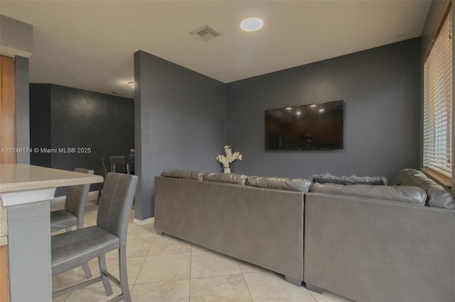 living room featuring light tile patterned flooring and visible vents