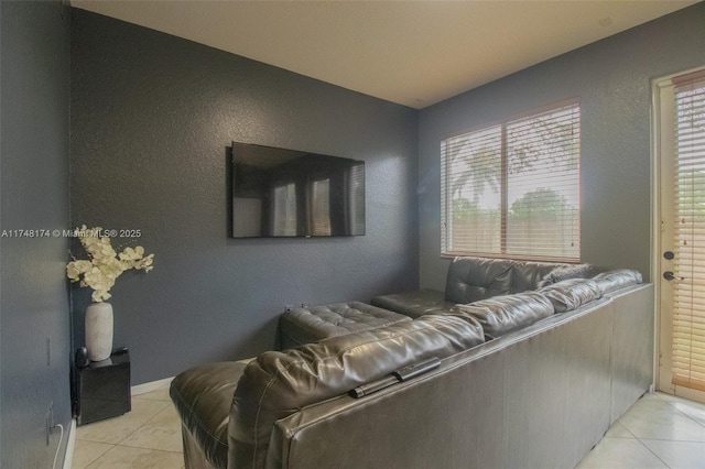 living room featuring light tile patterned floors and a textured wall