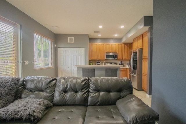 living area with light tile patterned floors, visible vents, and recessed lighting