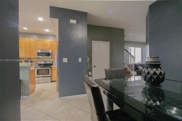 kitchen featuring light tile patterned floors, recessed lighting, stainless steel appliances, light countertops, and light brown cabinetry