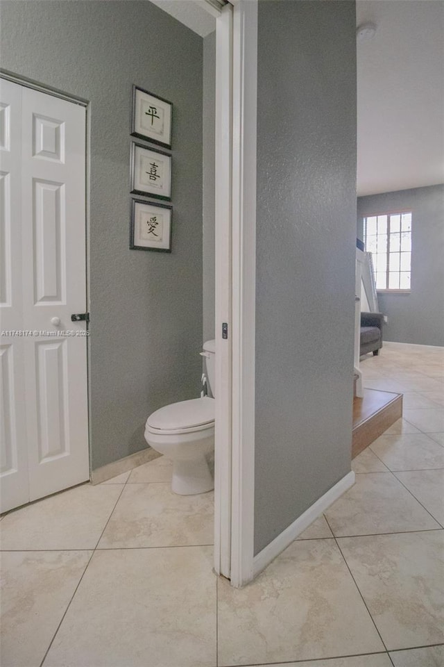 bathroom featuring baseboards, toilet, and tile patterned floors