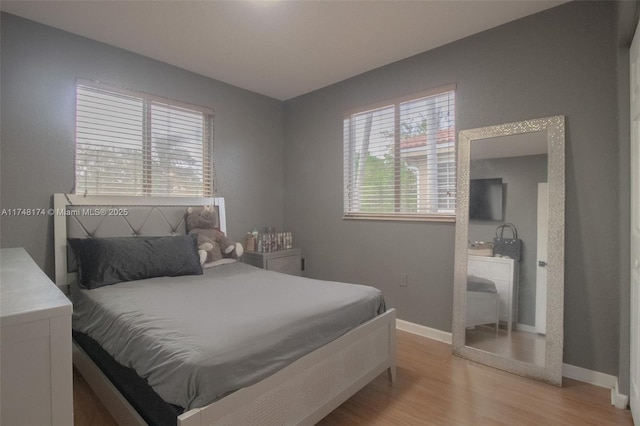 bedroom with light wood-style flooring and baseboards