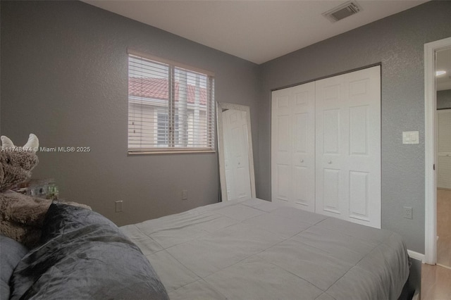 bedroom with a closet and visible vents