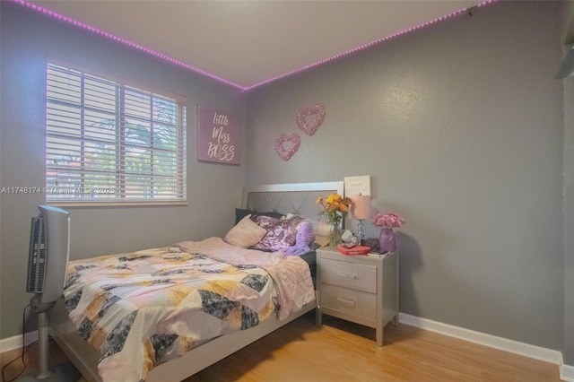 bedroom with light wood finished floors and baseboards