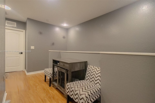 sitting room with baseboards, recessed lighting, visible vents, and light wood-style floors