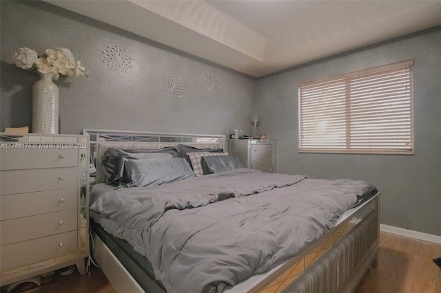 bedroom with baseboards and wood finished floors