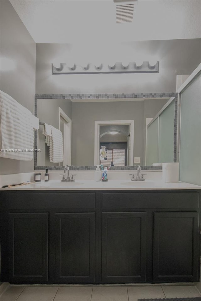 full bath featuring double vanity, tile patterned flooring, a sink, and visible vents