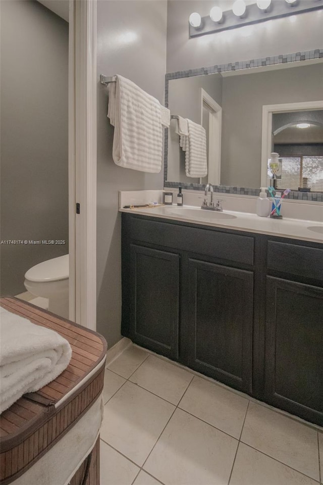 bathroom featuring tile patterned flooring, vanity, and toilet