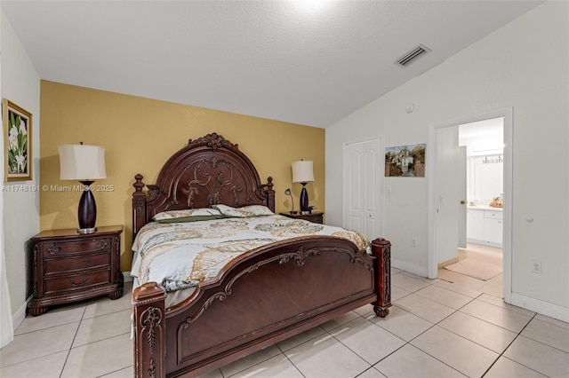 bedroom with baseboards, visible vents, lofted ceiling, a closet, and light tile patterned flooring