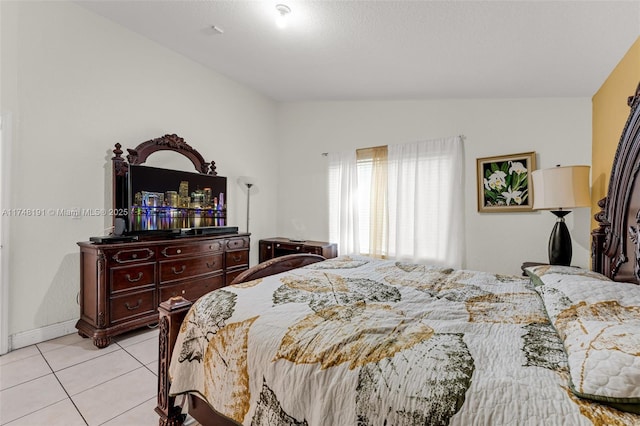 bedroom featuring light tile patterned floors and lofted ceiling