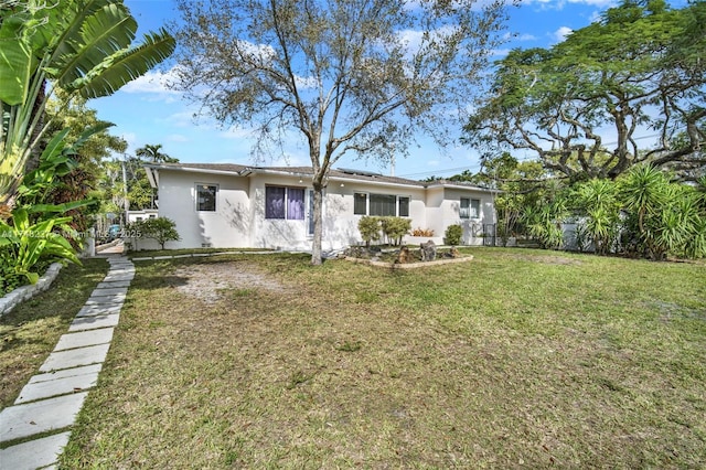 back of property with a yard and stucco siding