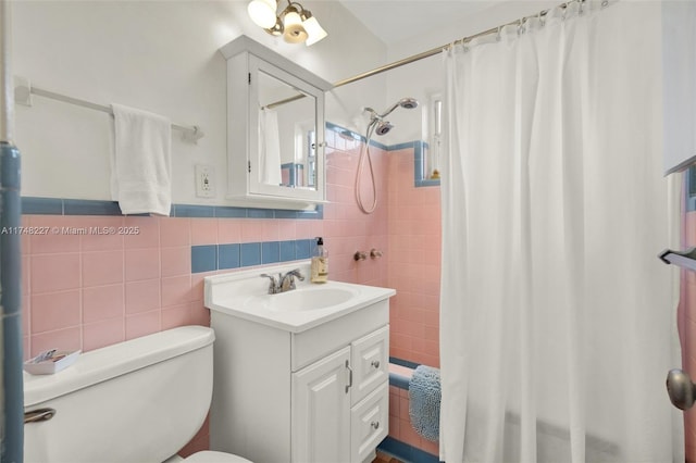 bathroom with toilet, vanity, shower / bathtub combination with curtain, and tile walls