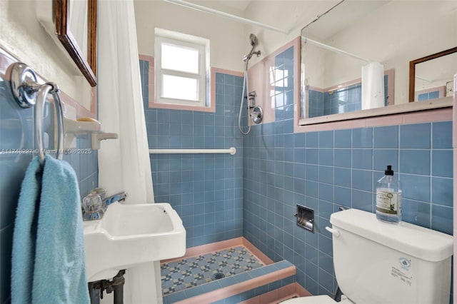 full bathroom featuring toilet, tile walls, a sink, and a stall shower