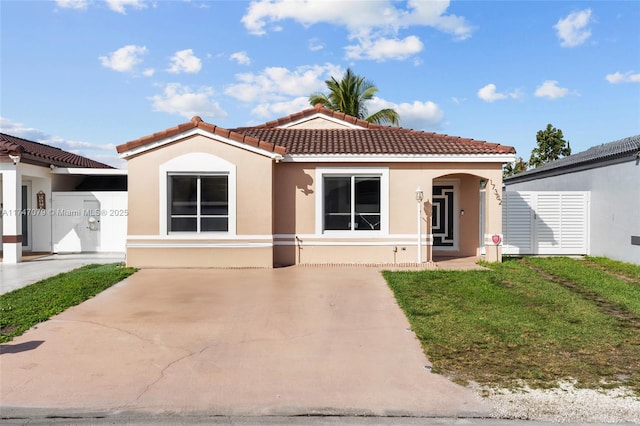 mediterranean / spanish home featuring a tiled roof and stucco siding