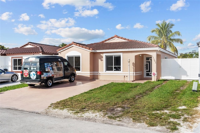 view of front of property featuring a tile roof, driveway, and stucco siding