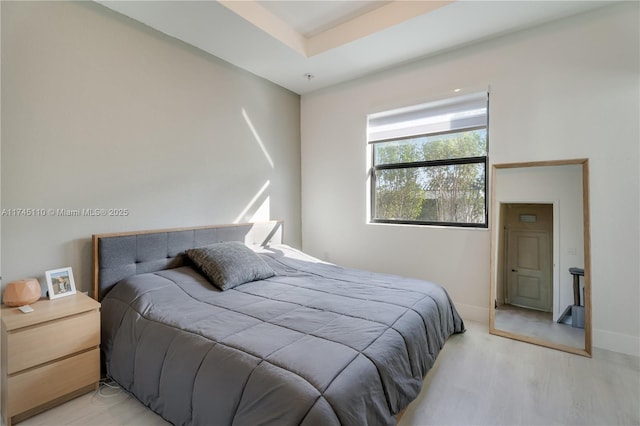 bedroom with light wood-type flooring and baseboards