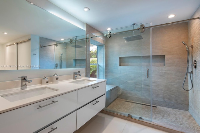 full bath with a sink, a stall shower, and double vanity