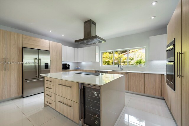 kitchen featuring range hood, beverage cooler, stainless steel built in fridge, modern cabinets, and a center island