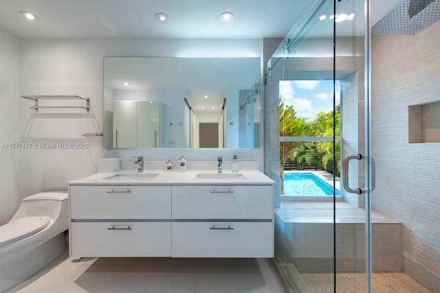 bathroom featuring double vanity, toilet, a stall shower, and a sink