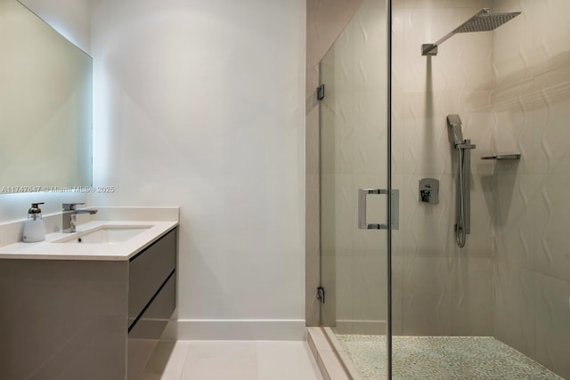 bathroom featuring a marble finish shower, baseboards, and vanity