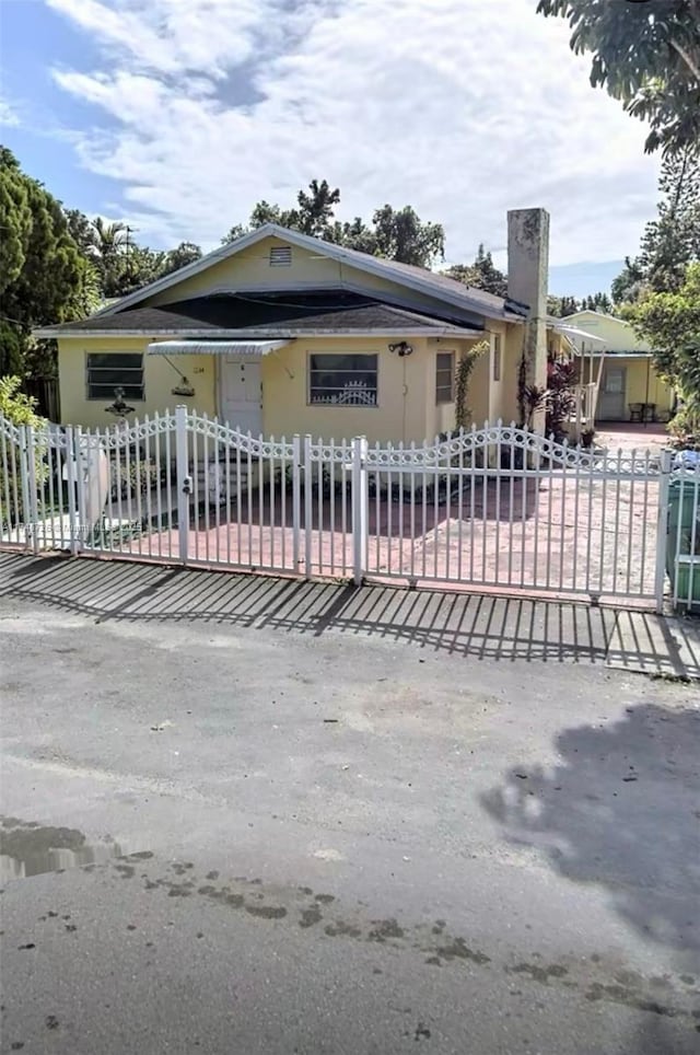 view of front of home with a fenced front yard and a chimney