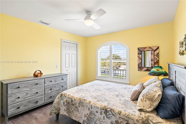 bedroom with ceiling fan, a closet, dark wood finished floors, and visible vents