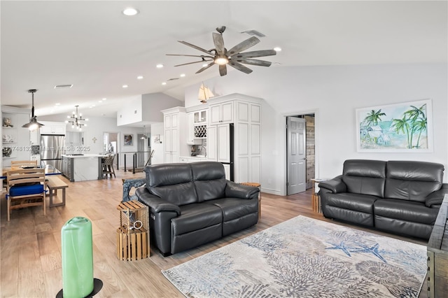 living area featuring visible vents, light wood-style flooring, ceiling fan with notable chandelier, vaulted ceiling, and recessed lighting