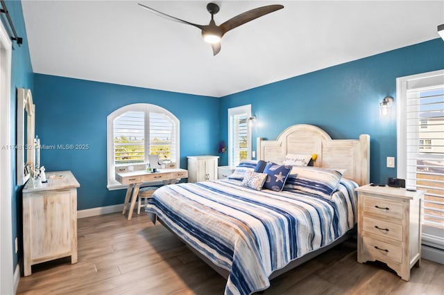 bedroom featuring dark wood-style floors, baseboards, and a ceiling fan